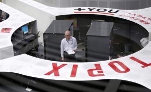 Tokyo Stock Exchange (TSE) staff members work at the bourse at TSE in Tokyo October 16, 2014. REUTERS/Yuya Shino