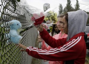 Student Tyanna Davis (R) and others place flowers outside Marysville-Pilchuck High School the day after a shooting at the school in Marysville, Washington October 25, 2014.  REUTERS/Jason Redmond