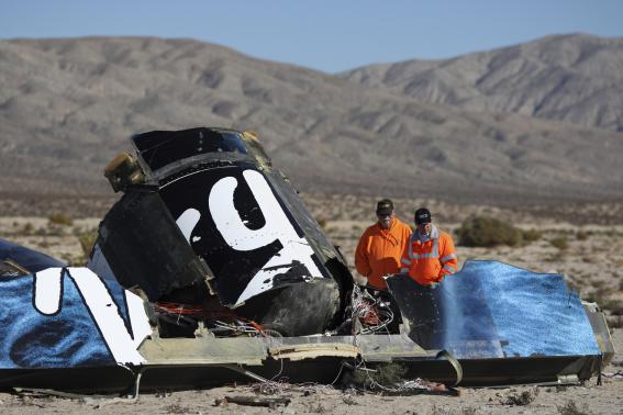 Sheriffs' deputies look at wreckage from the crash of Virgin Galactic's SpaceShipTwo near Cantil, California November 2, 2014. CREDIT: REUTERS/DAVID MCNEW