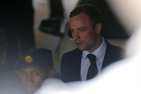 South African Olympic and Paralympic sprinter Oscar Pistorius is led to a prison van after his sentencing in Pretoria October 21, 2014. CREDIT: REUTERS/MIKE HUTCHINGS