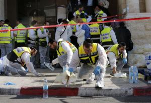Members of the Israeli Zaka emergency response team clean blood from the scene of an attack at a Jerusalem synagogue November 18, 2014.  REUTERS/Ammar Awad