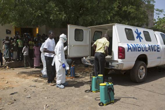 Health workers put on protective gear outside a mosque before disinfecting it, in Bamako November 14, 2014. CREDIT: REUTERS/JOE PENNEY