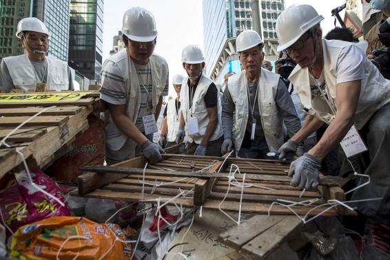 Workers dismantle a barricade at a small section in the Mongkok protest site after a court issued an eviction order in Hong Kong November 25, 2014.  REUTERS/Tyrone Siu