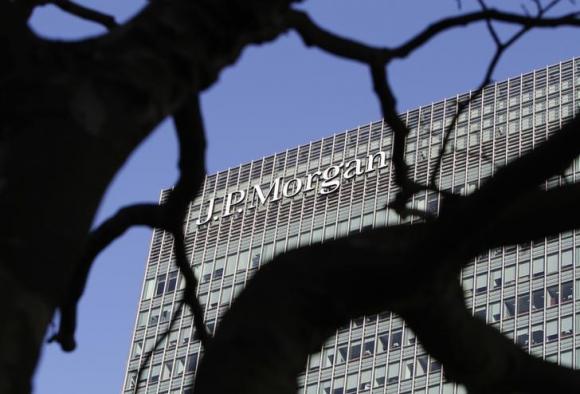 A sign on the Canary Wharf offices of JP Morgan is seen through the branches of a tree in London January 28, 2014. CREDIT: REUTERS/SIMON NEWMAN
