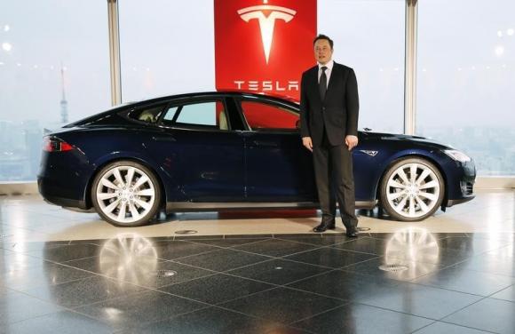 Tesla Motors Inc Chief Executive Elon Musk poses with a Tesla Model S electric car in Tokyo September 8, 2014.   REUTERS/Toru Hanai