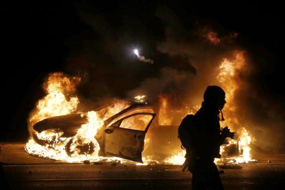  A police car burns on the street after a grand jury returned no indictment in the shooting of Michael Brown in Ferguson, Missouri November 24, 2014. CREDIT: REUTERS/JIM YOUNG