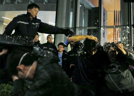 Pro-democracy protesters are pepper sprayed by a policeman as they try to break into the Legislative Council in Hong Kong early November 19, 2014, in response to an earlier clear up by bailiffs on part of the 'Occupy Central' protest site. CREDIT: REUTERS/TYRONE SIU