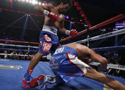  Chris Algieri of the U.S. falls as he takes a punch from Manny Pacquiao (L) of the Philippines during their World Boxing Organisation (WBO) 12-round welterweight title fight at the Venetian Macao More... CREDIT: REUTERS/TYRONE SIU