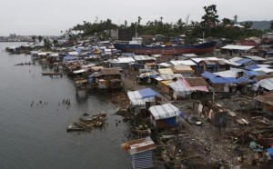 A view of temporary shelters for typhoon survivors that were constructed next to a ship that ran aground is pictured nearly 100 days after super Typhoon Haiyan devastated Tacloban city in central Philippines February 14, 2014. REUTERS/Erik De Castro