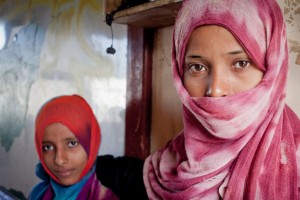 Two displaced girls stand in front of the classroom where their family has been living in Aden, Yemen. UNHCR/P. Rubio Larrauri