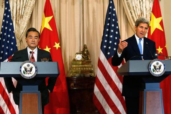U.S. Secretary of State John Kerry (R) delivers remarks as China's Foreign Minister Wang Yi (L) looks on, before their meeting at the State Department in Washington October 1, 2014. REUTERS/Jonathan Ernst