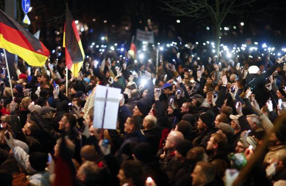 Participants hold up their mobile phones during a demonstration called by anti-immigration group PEGIDA, a German abbreviation for "Patriotic Europeans against the Islamization of the West", in More... CREDIT: REUTERS/HANNIBAL HANSCHKE