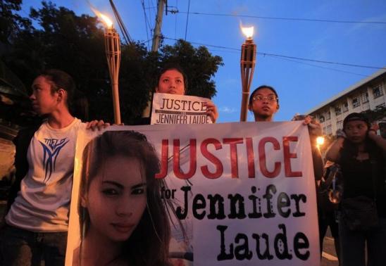 Demonstrators display a banner while holding torches, seeking justice for murdered Filipino transgender Jeffrey Laude, who also goes by the name Jennifer, during a protest in Manila