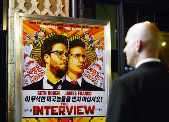 A security guard stands at the entrance of United Artists theater during the premiere of the film ''The Interview'' in Los Angeles, California December 11, 2014. CREDIT: REUTERS/KEVORK DJANSEZIAN