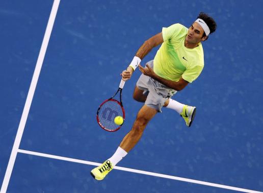 Roger Federer of Switzerland hits a return against Lu Yen-Hsun of Taiwan during their men's singles first round match at the Australian Open 2015 tennis tournament in Melbourne January 19, 2015. CREDIT: REUTERS/CARLOS BARRIA
