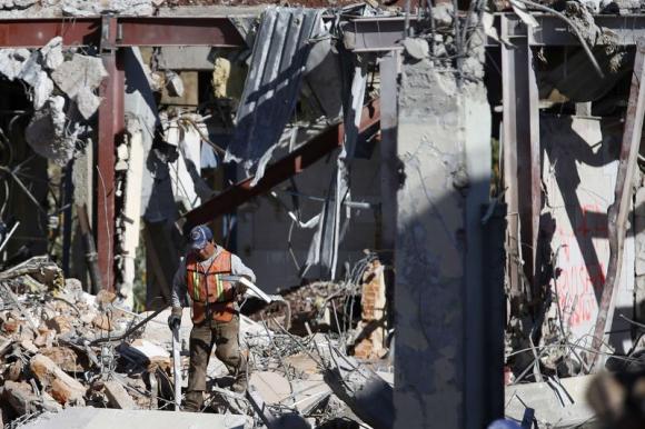A crew member works to clear debris the day after a deadly gas truck explosion ripped through a maternity hospital in Mexico City, January 30, 2015. CREDIT: REUTERS/EDGARD GARRIDO