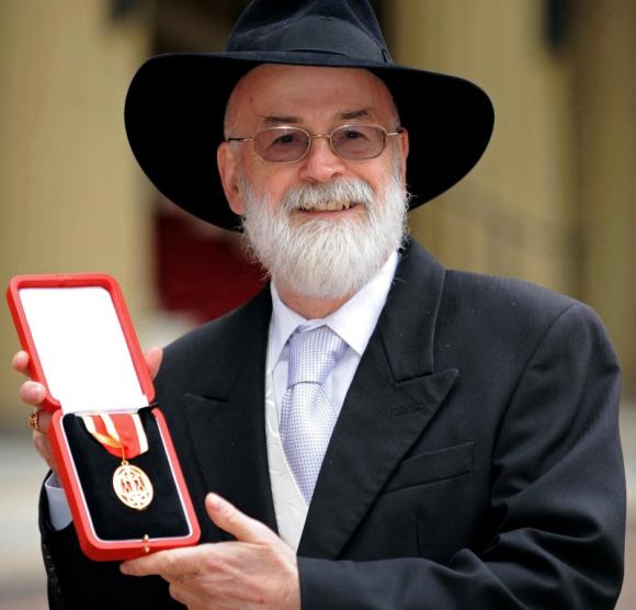 British author Terry Pratchett poses for photographers after receiving his knighthood from Britain's Queen Elizabeth at Buckingham Palace in London February 18, 2009. CREDIT: REUTERS/IAN NICHOLSON/POOL
