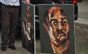 A lawyer for two Australian drug convicts on death row in Indonesia displays three self-portraits painted by one of the men facing a firing squad imminently. (Photo grabbed from Reuters video/Courtesy Reuters)