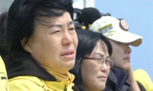 Family members of South Korean sunken ferry victims visit the spot of the deadly South Korean ferry sinking and offer flowers, one day before the disaster's first anniversary. (Photo grabbed from Reuters video/Courtesy Reuters)