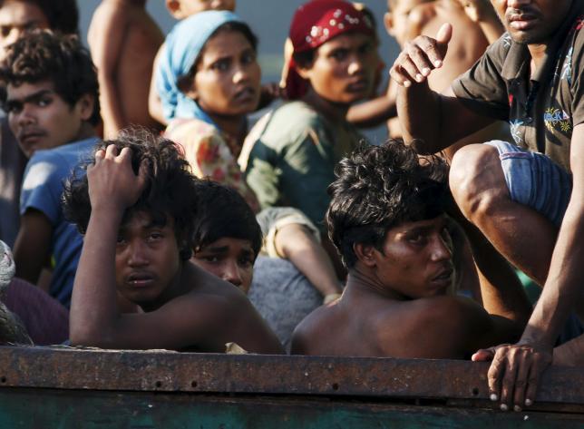 Migrants are seen aboard a boat tethered to a Thai navy vessel, in waters near Koh Lipe island, May 16, 2015.  REUTERS/Olivia Harris (THAILAND)