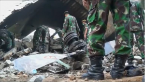 Rescuers continue to remove victims from the site where a military transport plane ploughed into residential area in northern Indonesia, as fears that the death toll could exceed 140 grow. (Courtesy Reuters/Photo grabbed from Reuters video)