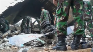 Rescuers continue to remove victims from the site where a military transport plane ploughed into residential area in northern Indonesia, as fears that the death toll could exceed 140 grow. (Courtesy Reuters/Photo grabbed from Reuters video) 