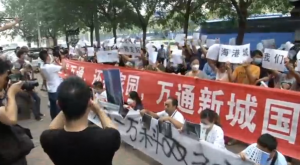 Hundreds of angry residents whose homes were destroyed in the Tianjin explosions gather outside an official news conference venue demanding answers.  (Photo grabbed from Reuters video/Courtesy Reuters)