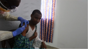  Man being injected by doctor with Ebola trial vaccine.  (Courtesy Reuters/Photo grabbed from Reuters video)