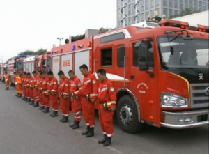 Officials, firefighters, policemen and locals mourn the victims of the massive Tianjin warehouse blasts at the accident site in north China's port city of Tianjin on Tuesday. (Courtesy China Central Television news/Photo grabbed from CCTV video)