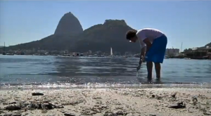 Man collecting water from the Guanabara Bay in front of Sugarloaf mountain in Rio de Janeiro, Brazil. Debate over the polluted Guanabara Bay further deepened as privately commissioned tests of the water quality, where rowers, sailors and open water swimmers will be competing, revealed this week a high level of disease-causing viruses.  (Photo grabbed from Reuters video)