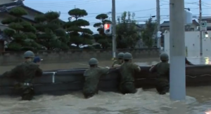 Self-defense forces of Japan help rescue people stranded in floods using boats. (Photo grabbed from Reuters video)