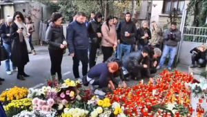 People grieve after a fire killed 27 people and injured 164 during a rock concert that featured fireworks used indoors in a Bucharest nightclub.  (Photo grabbed from Reuters video)