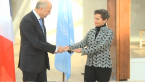 French Foreign Minister Laurent Fabius hands over the key to Le Bourget to United Nations climate chief Christiana Figueres on Saturday, This act symbolizes a shift of the administration power of the commune to the UN ahead of the 2015 UN climate change conference in Paris. (Courtesy CCTV)