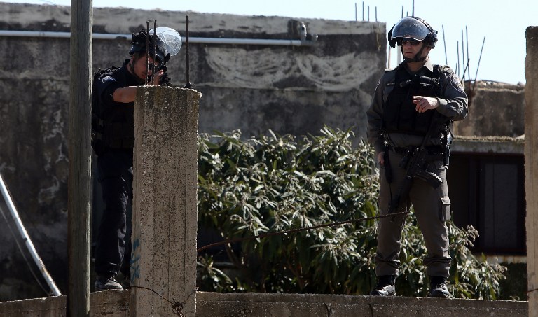 An Israeli soldier aims his weapon during clashes with Palestinian protesters following a demonstration against the expropriation of Palestinian land by Israel on February 12, 2016 in the village of Kfar Qaddum, near Nablus in the occupied West Bank. / AFP / JAAFAR ASHTIYEH