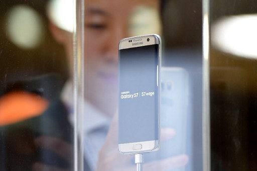 A visitor takes a photo of the new Galaxy 7 mobile device by South Korean multinational conglomerate corporation Samsung presented on February 21, 2016 on the eve of the official opening of the Mobile World Congress in Barcelona. The world's biggest mobile fair, Mobile World Congress, is held from February 22 to February 25. / AFP / LLUIS GENE