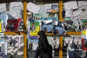 An Iranian woman walks past electoral posters for upcoming parliamentary elections in downtown Tehran on February 25, 2016. / AFP / BEHROUZ MEHRI