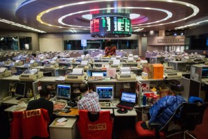 Traders work on the trading floor of the stock exchange in Hong Kong on February 3, 2016. Hong Kong stocks plunged in the morning session on February 3 as another sell-off in oil hammered energy firms, while insurance companies were also hit by a report China would clamp down on the purchase of overseas cover. AFP PHOTO / ANTHONY WALLACE 