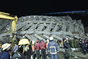 (FILES) This file picture taken on February 6, 2016 shows rescue personnel working at the site of a collapsed building in the southern Taiwanese city of Tainan following a strong 6.4-magnitude earthquake. As rescuers continue the grim task of digging bodies from the rubble of an apartment complex that collapsed in a Taiwan earthquake, anger is growing over the shoddy construction of the building and the island's questionable safety record. AFP PHOTO / Sam Yeh / FILES / AFP / SAM YEH
