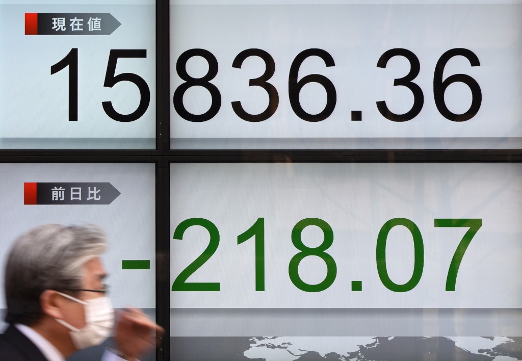 A businessman walks past an electric quotation board flashing the Nikkei key index of the Tokyo Stock Exchange (TSE) in front of a securities company in Tokyo on February 17, 2016. Tokyo stocks fell on February 17, ending a two-day rally as a pick-up in the yen held back exporters and uncertainty hung over world oil output. AFP PHOTO / Toru YAMANAKA / AFP / TORU YAMANAKA