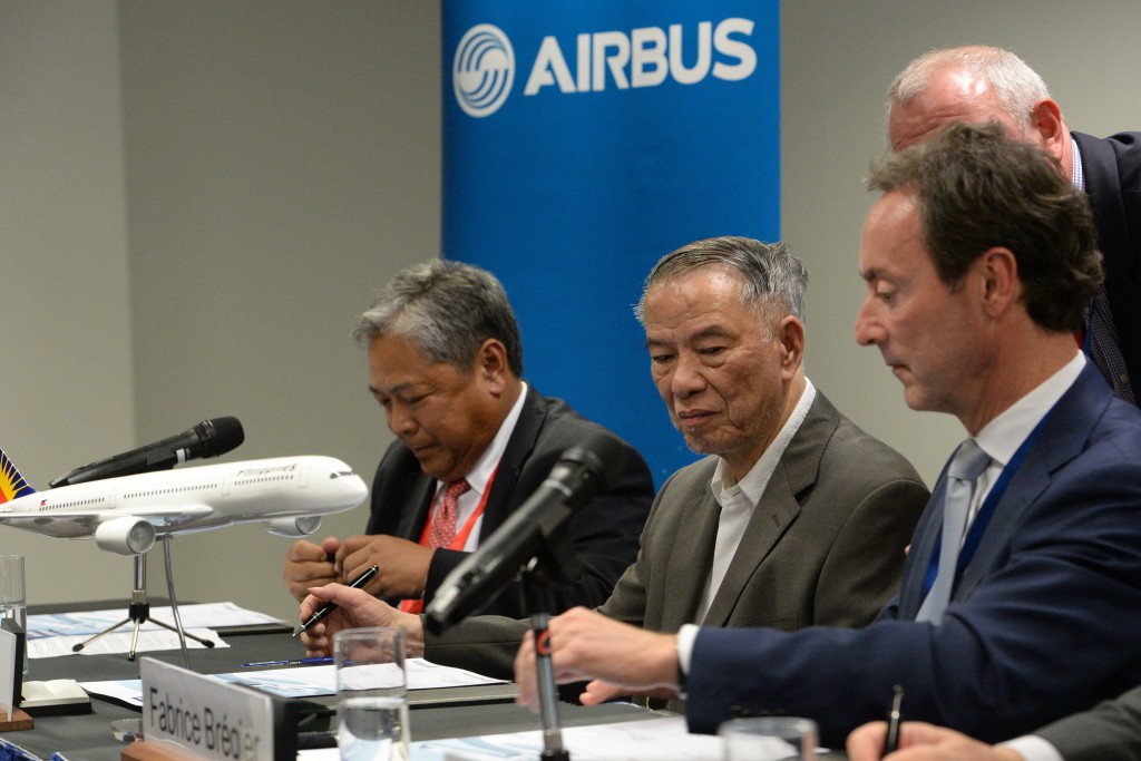 Philippine Airlines president Jaime Bautista (L), Philippine Airlines chairman Lucio Tan (C) and Airbus CEO Fabrice Bregier (R) sign a purchase agreement for six Airbus A350-900 aircraft at the Singapore Airshow at the Changi exhibition centre in Singapore on February 17, 2016. European plane-maker Airbus said February 17 it had won a 1.85 billion USD deal for the purchase of six A350-900s by Philippine Airlines (PAL). AFP PHOTO / ROSLAN RAHMAN ROSLAN RAHMAN / AFP