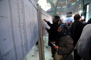 Iranian voters check a list of candidates at a mosque being used as a polling station in Tehran on February 26, 2016. Iranians began voting across the country in elections billed by the moderate president as vital to curbing conservative dominance in parliament and speeding up domestic reforms after a nuclear deal with world powers. AFP PHOTO / ATTA KENARE / AFP / ATTA KENARE