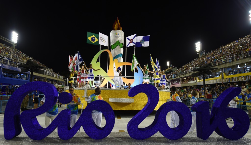A sign of the Rio 2016 Olympic is seen in front of dancers during the opening ceremony on the first day of parades at the Sambadrome in Rio de Janeiro, Brazil on February 7, 2016. / AFP / VANDERLEI ALMEIDA