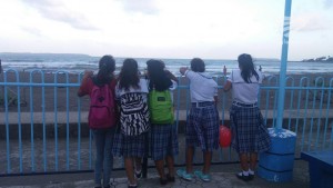 School kids watching the waves along Baybay boulevard in Borongan City.