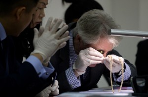Christie's and Sotheby's auction house appraiser David Warren (R) examines diamond jewellery seized by the Philippine government from former first lady Imelda Marcos, at the Central Bank headquarters in Manila on November 24, 2015. Philippine authorities on November 24 showcased a dazzling collection of jewels seized from the family of the late dictator Ferdinand Marcos appraised in preparation for a possible auction. The long-hidden collection, seized in three batches after Marcos was overthrown in 1986, also provides a stark look at how the Marcos family enriched itself while the nation sank deeper into poverty. AFP PHOTO / NOEL CELIS / AFP / NOEL CELIS