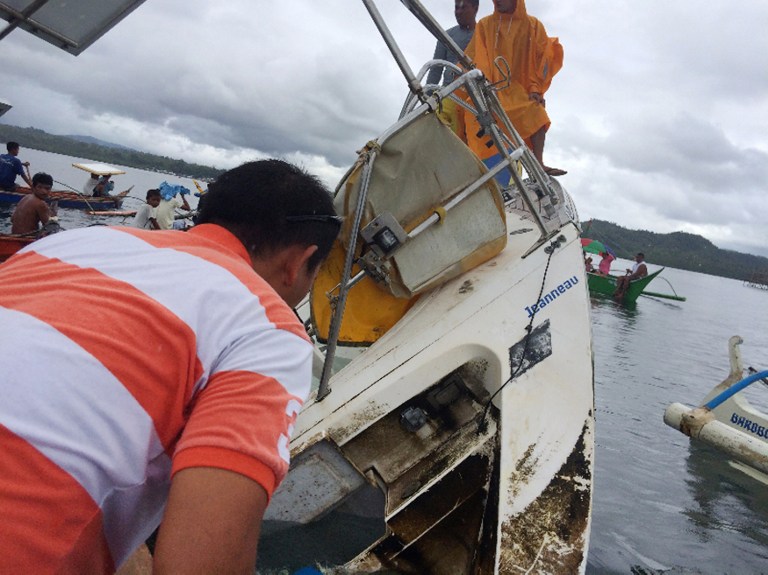 This recent undated handout photo released by Barobo police station on March 2, 2016 shows people standing on a partially-capsized boat believed to be owned by German national Manfred Fritz Bajorat whose body was found inside, after residents found the yatch drifting off the coast of Barobo, on the southern Philippine island of Mindanao. The German man whose mummified body was found on a yacht adrift off the southern Philippines had died of a heart attack about a week earlier, according to an autopsy report released on March 2. AFP PHOTO/Barobo Police --EDITORS NOTE---RESTRICTED TO EDITORIAL USE - MANDATORY CREDIT "AFP PHOTO / BAROBO POLICE" - NO MARKETING NO ADVERTISING CAMPAIGNS - DISTRIBUTED AS A SERVICE TO CLIENTS / AFP / BAROBO POLICE / BAROBO POLICE