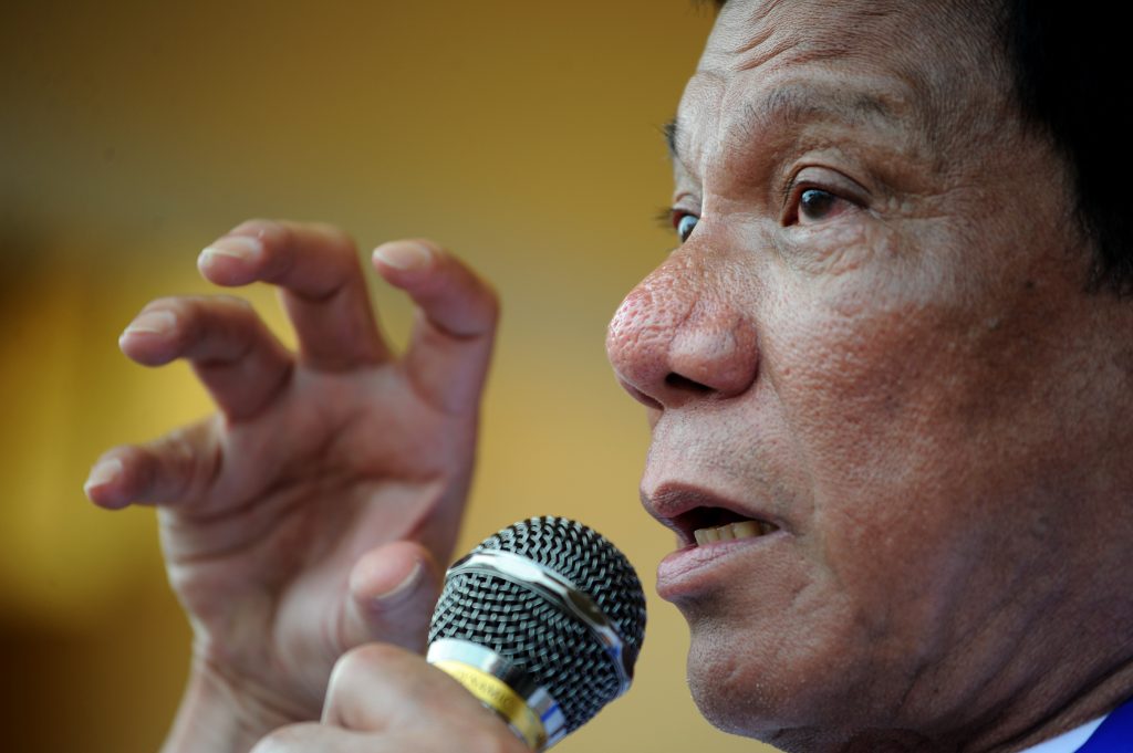 In this photo taken on March 2, 2016, Davao City Mayor and Presidential Candidate Rodrigo Duterte stating his political platform during his campaign sortie in Lingayen, Pangasinan, north of Manila. Rodrigo Duterte curses the pope's mother and jokes about his own infidelities, but many voters in the Philippines want to elect him president so he can begin an unprecedented war on crime. / AFP PHOTO / NOEL CELIS / TO GO WITH AFP STORY: Philippines-vote-rights-crime-Duterte, FOCUS by Karl Malakunas