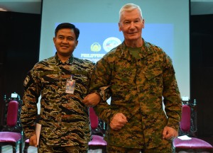 Philippine exercise director Vice-Admiral Alexander Lopez (L) and his US counterpart Lieutenant General John Toolan link arms during the opening ceremony of the annual joint 11-day Balikatan (Shoulder-to-Shoulder) military exercise in Manila on April 4, 2016. US and Philippine troops began major exercises on April 4 as China's state media warned "outsiders" against interfering in tense South China Sea territorial disputes. / AFP / TED ALJIBE