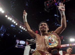 Manny Pacquiao gestures to fans celebrating after defeating Timothy Bradley Jr. in a 12 round unanimous decision at the MGM Grand Arena on April 9, 2016 in Las Vegas, Nevada.  Pacquio captured the WBO International Welterweight Title. / AFP PHOTO / John GURZINSKI