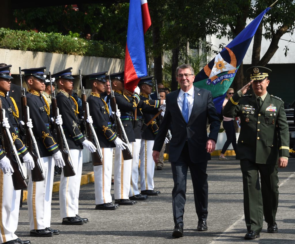 US Defense Secretary Ashton Carter (L) accompanied by Philipine vice-chief of staff, Lieutenant General Glorioso Miranda (R), review the honour guard as he arrives for the closing ceremony of the US-Philippines annual joint military execise at Camp Aguinaldo in Quezon city, suburban Manila on April 15, 2016. US Defence Secretary Carter said he would visit a warship close to flashpoint waters of the South China Sea on April 15, as Beijing reacted defiantly to an American military build-up in area. / AFP PHOTO 