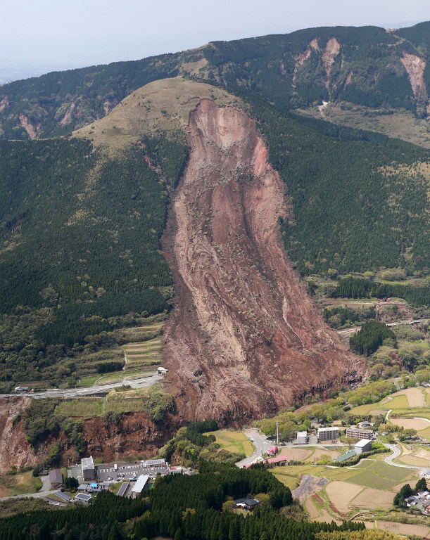 The aerial view shows a landslide caused by a big earthquake before dawn in Mimami-Aso, Kuammoto prefecture, on April 16, 2016.  A more powerful quake hit southern Japan, killing at least ten people, toppling large buildings and triggering a massive landslide just over a day after an earlier tremor which left nine dead.     / AFP PHOTO / JIJI PRESS / JIJI PRESS / Japan OUT